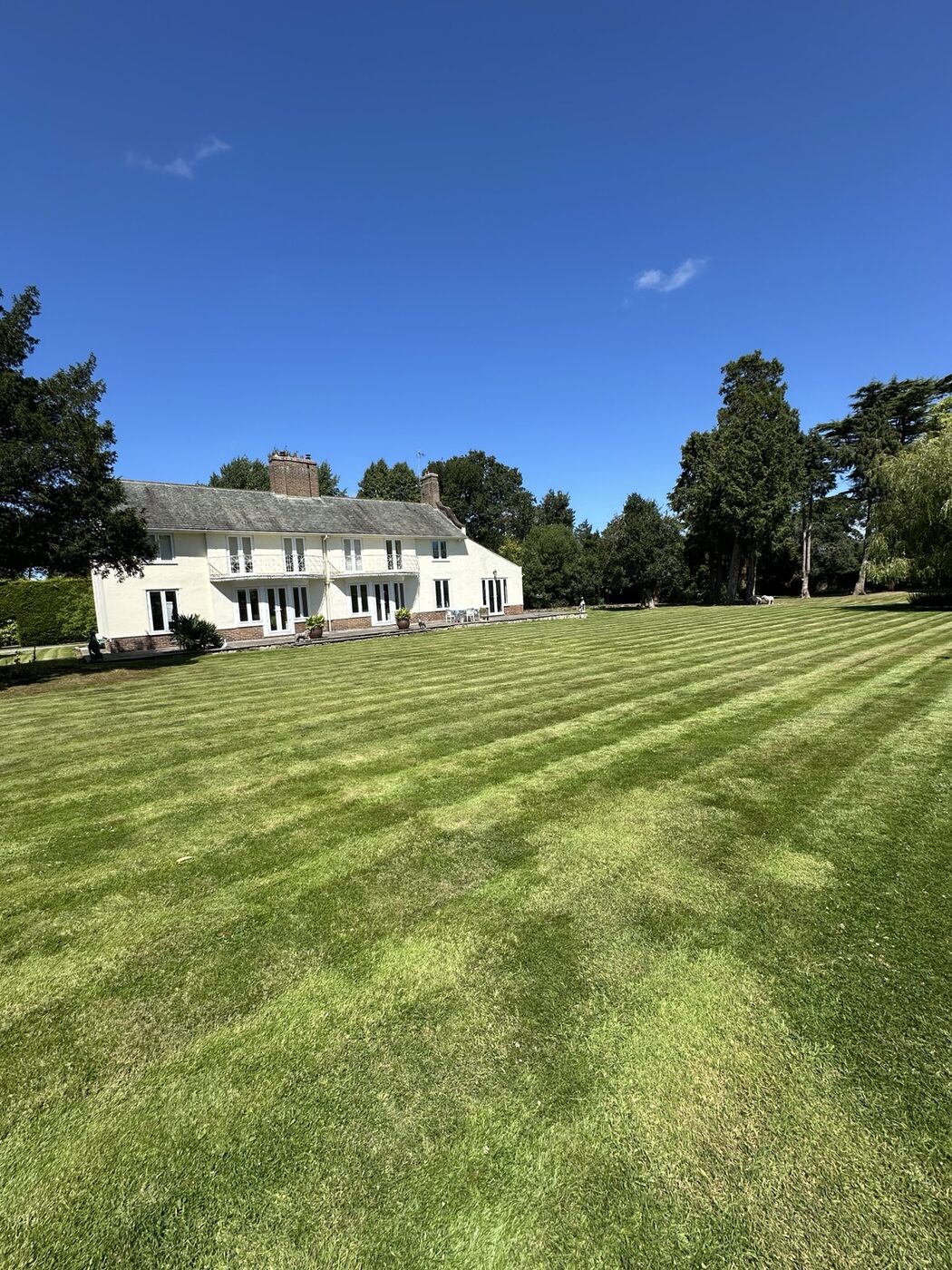 Large striped lawn maintained in front of a country home